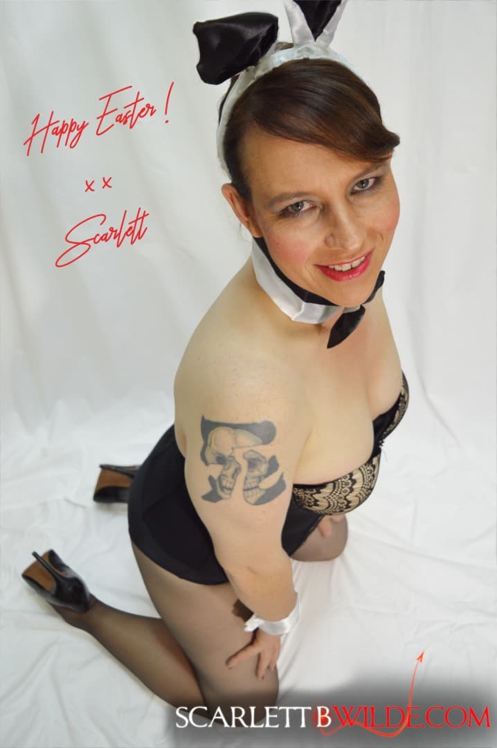 Australian Mature Escort Scarlett B Wilde kneels wearing a PlayBoy Bunny Outfit staring lovingly into your eyes.The downwards view puts her breasts on display.