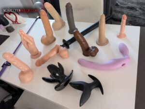 A collection of anal toys owned by Sydney Based Mature Escort Scarlett B Wilde is laid out on the table for display. These toys range in size / colours / type.